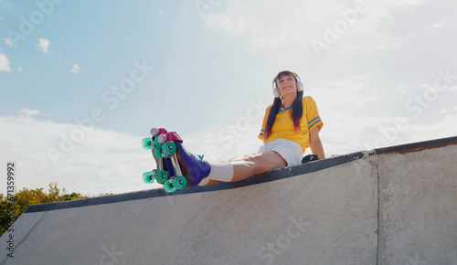 Sports, music and rollerblades with woman in skate park for summer break, streaming and mockup. Fitness, peace and skating with girl listening to headphones in outdoors for hobby, freedom and peace