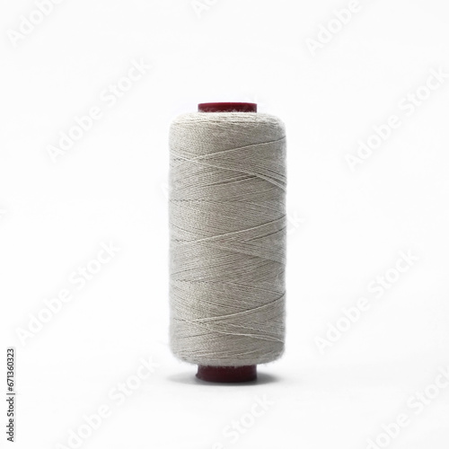 Grey thread and needle over white