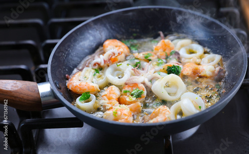 garlic shrimp and octopus in butter and parsley sauce- Frying seafood in a wok pan