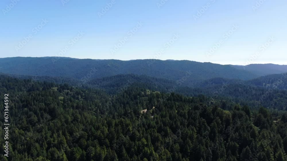 Drone video shot of a green landscape in Santa Cruz mountains, surrounded by a pine forest, a lot of vegetation and a blue sky all over the horizon. Drone video shot of a green landscape in Santa Cruz mountains, surrounded by a pine forest, a lot of vegetation and a blue sky all over the horizon.