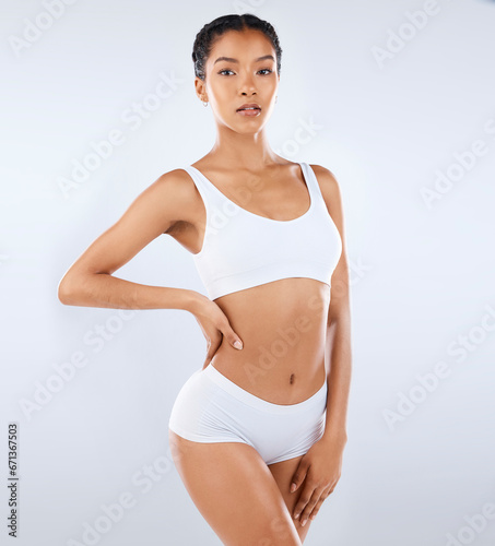 Beauty, skincare and body care, portrait of woman in underwear with healthy diet, exercise and pose in studio. Fitness, nutrition and health, wellness and slim fit figure isolated on grey background. © C. Daniels/peopleimages.com