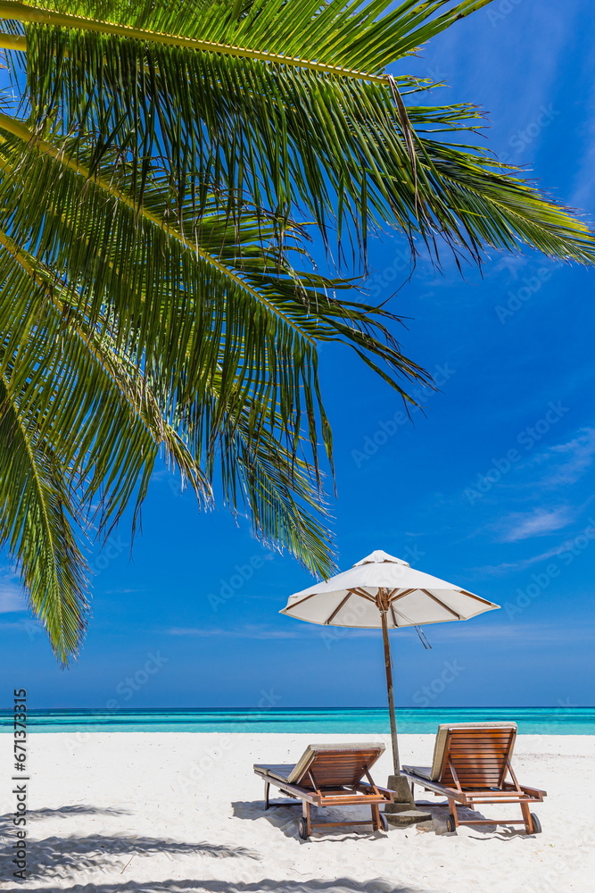 Tropical paradise beach white sand coconut palm trees majestic sea. Vertical panorama romantic chairs umbrella sunny landscape. Luxury vacation holiday banner tropical resort. Beautiful coast serene