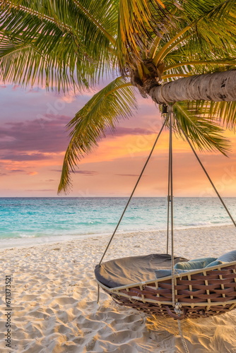 Beautiful tropical Maldives beach under cloudy sunset sky. romantic swing hanging on coconut palm. Luxury vacation travel. Inspiration honeymoon mood, calm couple beach background. Amazing landscape photo
