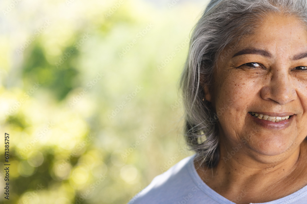 Half face of of happy biracial senior woman smiling in sunny garden, copy space Half face of of happy biracial senior woman smiling in sunny garden, copy space