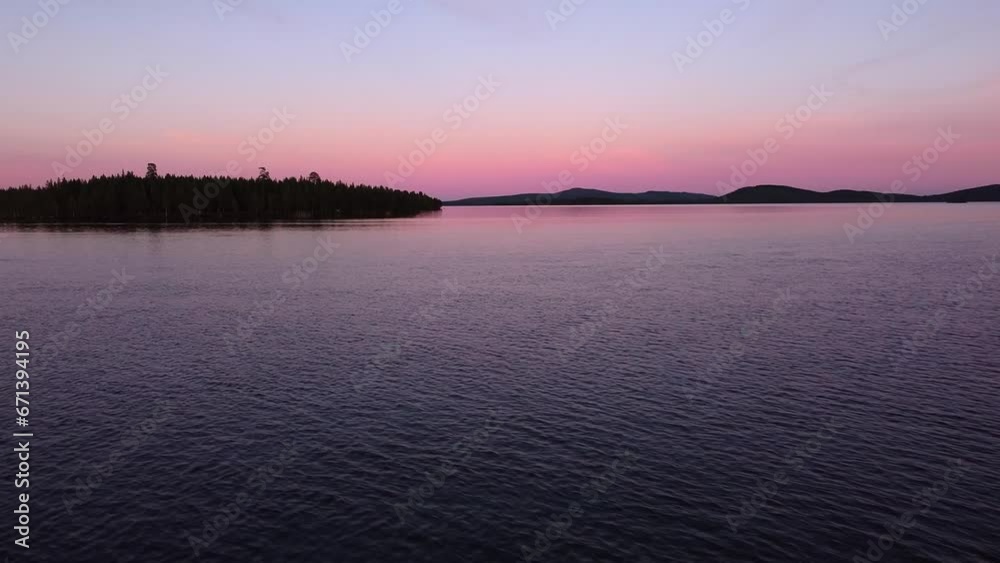 Picturesque evening dusk blue hour aerial over calm lake in Sweden. Orange blue sky with forest nature landscape silhouettes, flying over island Picturesque evening dusk blue hour aerial over calm lake in Sweden. Orange blue sky with forest nature landscape silhouettes, flying over island