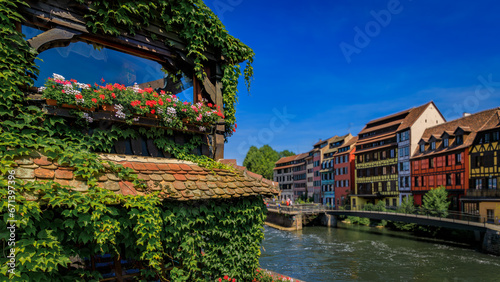 Ornate traditional half timbered houses with blooming flowers along the canals in the picturesque Petite France district of Strasbourg, Alsace, France 