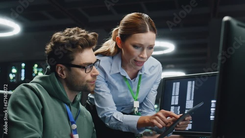 Data center analysts working in server room closeup. IT specialist showing data