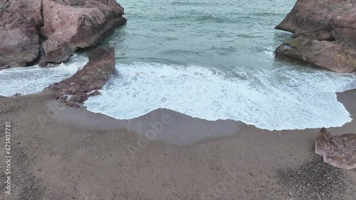 Aerial drone top down shot over sea waves crashing along Gadani Beach in Balochistan, Pakistan during evening time. photo