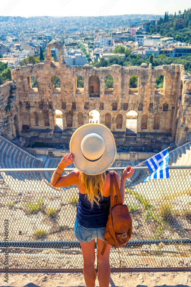 Woman tourist with Greek flag enjoying view ofTheatre of Herodion Atticus, Athens, Greece
