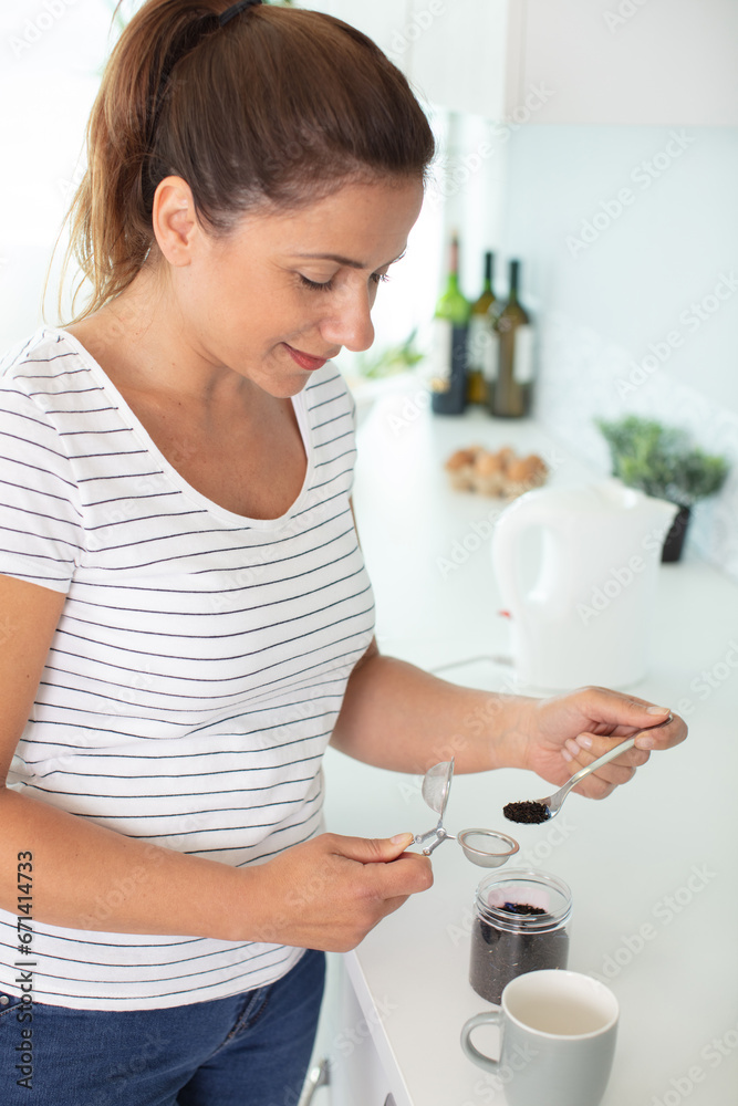 woman using kettle for make tea on kitchen woman using kettle for make tea on kitchen
