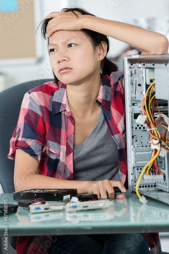 Wallpaper Mural a frustrated young woman trying to repair a pc Torontodigital.ca