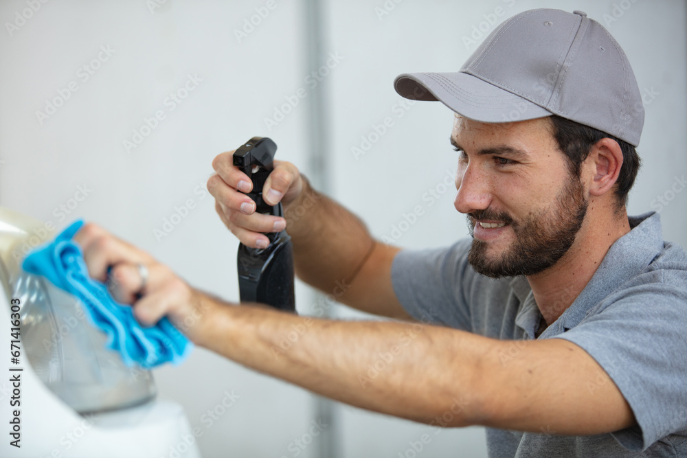man holds the microfiber in hand and polishes the car