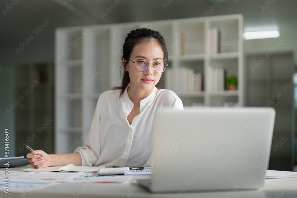 Portrait of beautiful young businesswoman asian sitting at office modern work station and typing on laptop - obrazy, fototapety, plakaty 