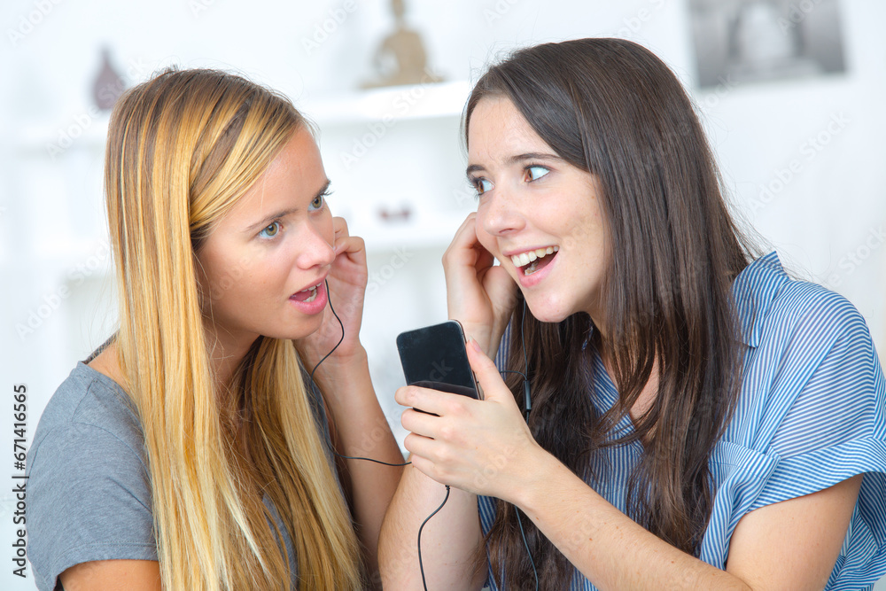 young girls sisters sharing a smart phone young girls sisters sharing a smart phone
