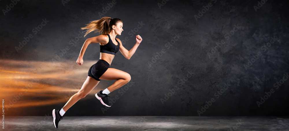 A strong athletic, woman sprinter, running on dark background wearing in the sportswear, fit