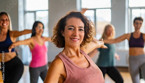 Middle-aged woman standing in a fitness studio, candidly expressing their active lifestyle through sport with friends