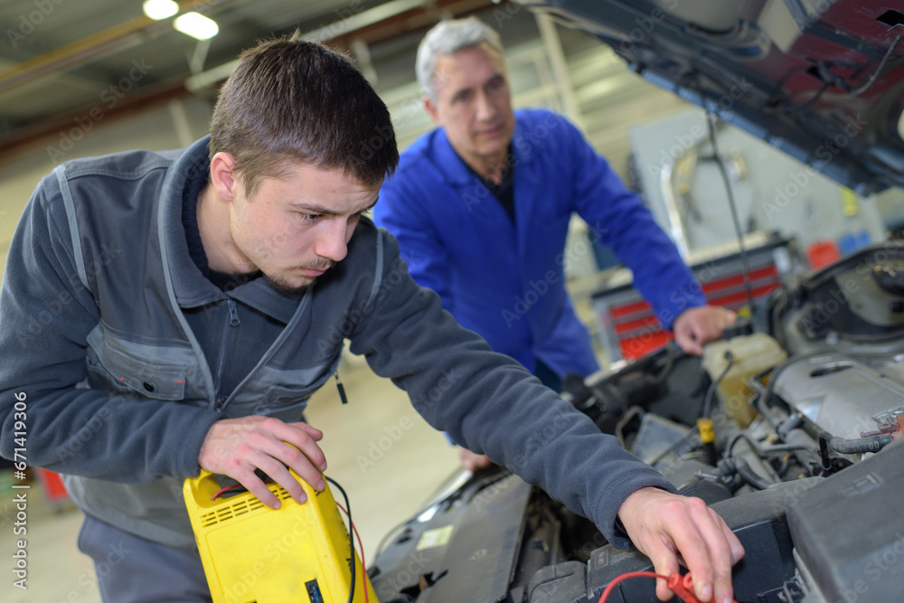 auto mechanic shows trainee maintenance of the engine auto mechanic shows trainee maintenance of the engine