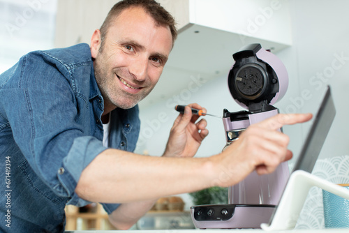serious man repairing broken coffee machine