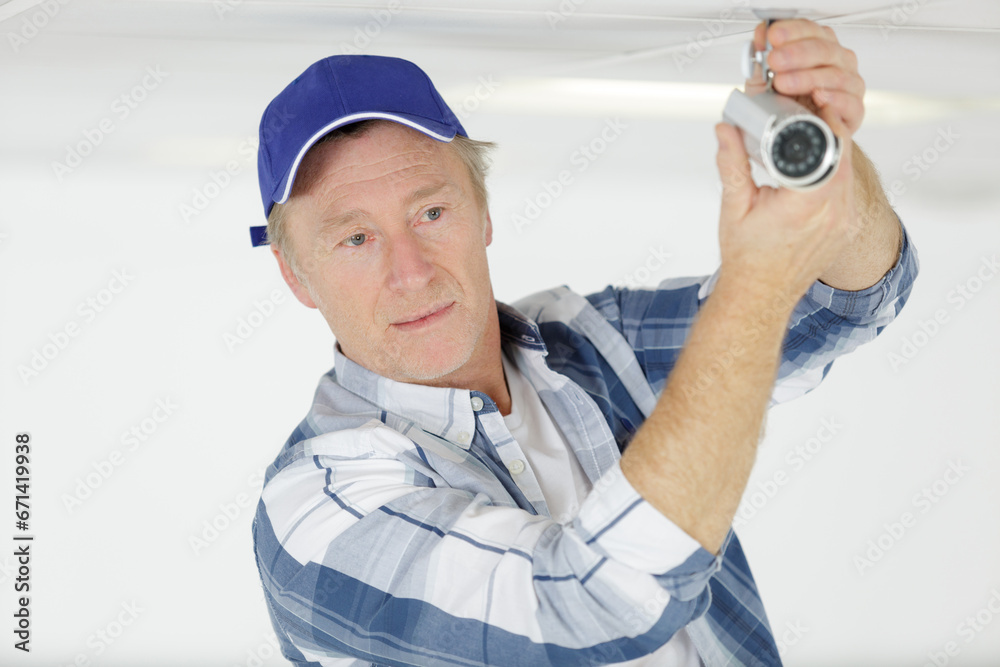 technician worker installing video surveillance camera on wall technician worker installing video surveillance camera on wall