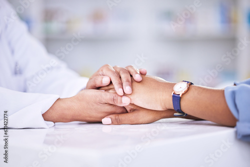 Woman, pharmacist and holding hands for healthcare, support or trust on counter at the pharmacy. Closeup of female person or medical professional with patient in care for consultation, help or advice
