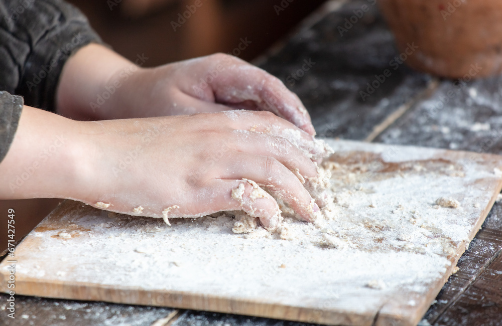 A woman kneads the dough with her hands A woman kneads the dough with her hands