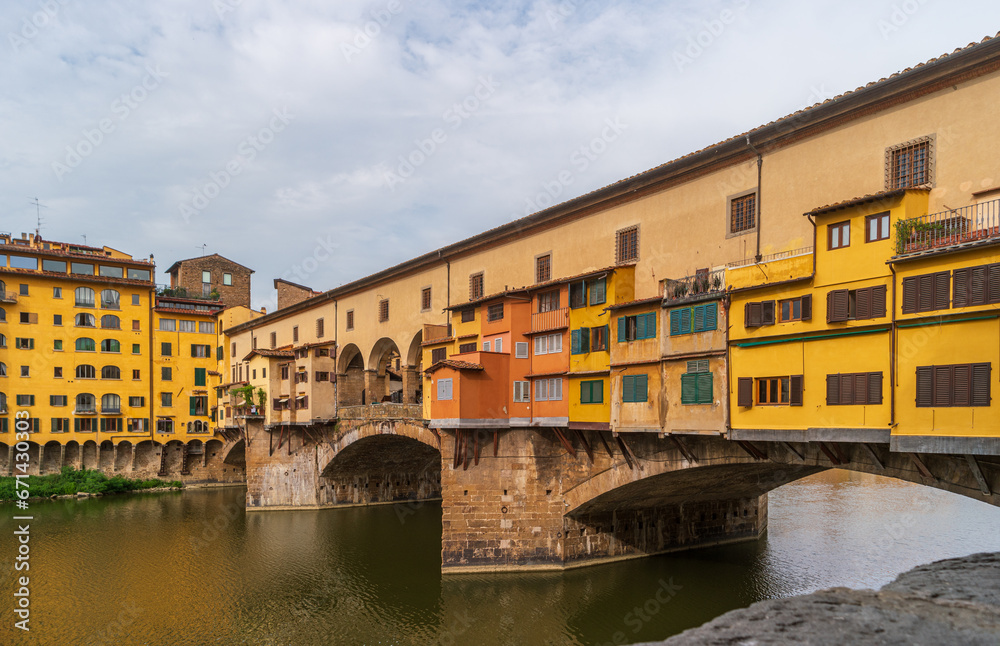 Florence, Italy. Bright colors of the Ponte Vecchio bridge over the Arno river on a summer day. Famous tourist attraction in the Italian region of Tuscany.