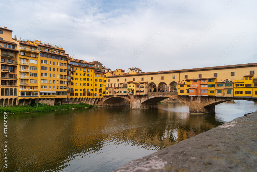 Florence, Italy. View of the Ponte Vecchio bridge over the Arno river on a summer day. Famous tourist attraction in the Italian region of Tuscany.