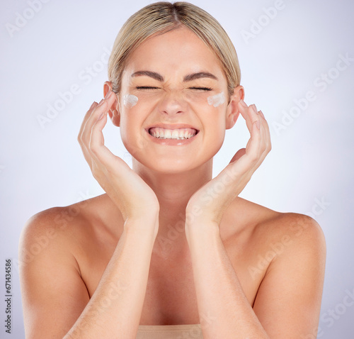 Cosmetics, face and woman with cream application for facial hydration, dermatology or glowing skincare shine. Studio, sunscreen or person with allergic reaction to lotion product on purple background