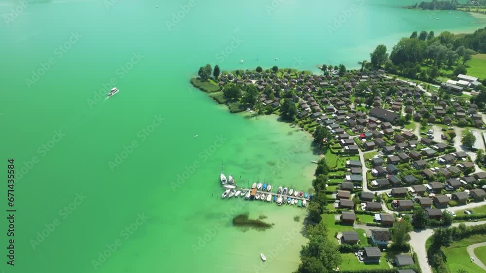 Captivating aerial view of Mondsee's serene emerald waters, revealing a luxurious lakeside village and leisurely boats, a perfect Austrian holiday scene. LuPa Creative.