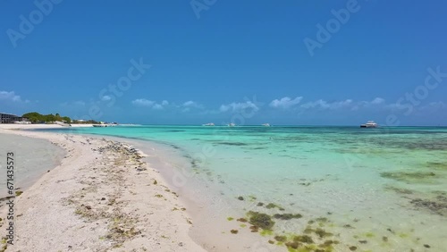 Pan left white sand beach and crystal blue water , madrisqui tropical island Los Roques photo