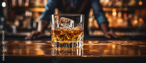 Obraz na plátně close up of a glas of whiskey on the rocks with blurred Bartender and bar in the