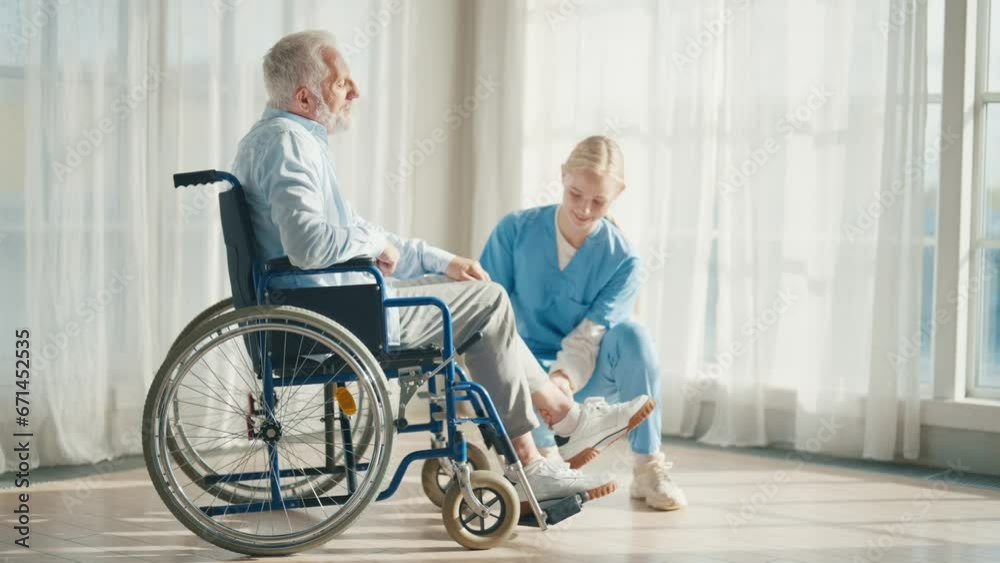 Young physiotherapist helping man in wheelchair to do exercises. Woman carer helping special disabled health problem by doing exercises sitting. Physical rehabilitation and disability care concept. Young physiotherapist helping man in wheelchair to do exercises. Woman carer helping special disabled health problem by doing exercises sitting. Physical rehabilitation and disability care concept.