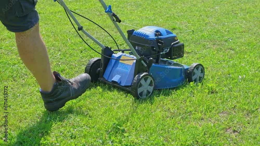 Lawn mower cutting grass. Small grass cuttings fly out of lawnmower. Grass clippings get spewed out of a mower pushed around by landscaper. CloseUp. Gardener working with mower machine. Mowing lawn	
