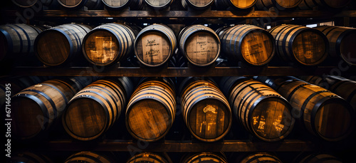 Rows of traditional full whisky barrels, set down to mature, in a large warehouse facility, Whiskey, bourbon, scotch barrels in an aging facility photo