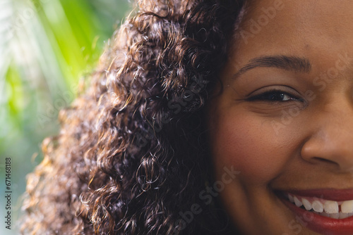 Portrait of happy african american woman in bright living room at home, close up photo