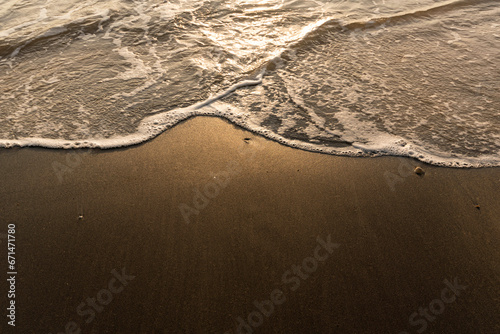 Black Sand with wave At Nang Thong Beach, Phang-nga Province, Thailand. The most popular beach of Khao Lak, Thailand. Black sandy beach with tin has been washed up on the beach with water. Copy space.