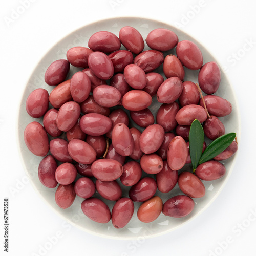 Delicious pink olives in plate with olive tree sprig decoration isolated on white background top view for your design. Healthy eating, healthy fats for humans. Organic vegetable