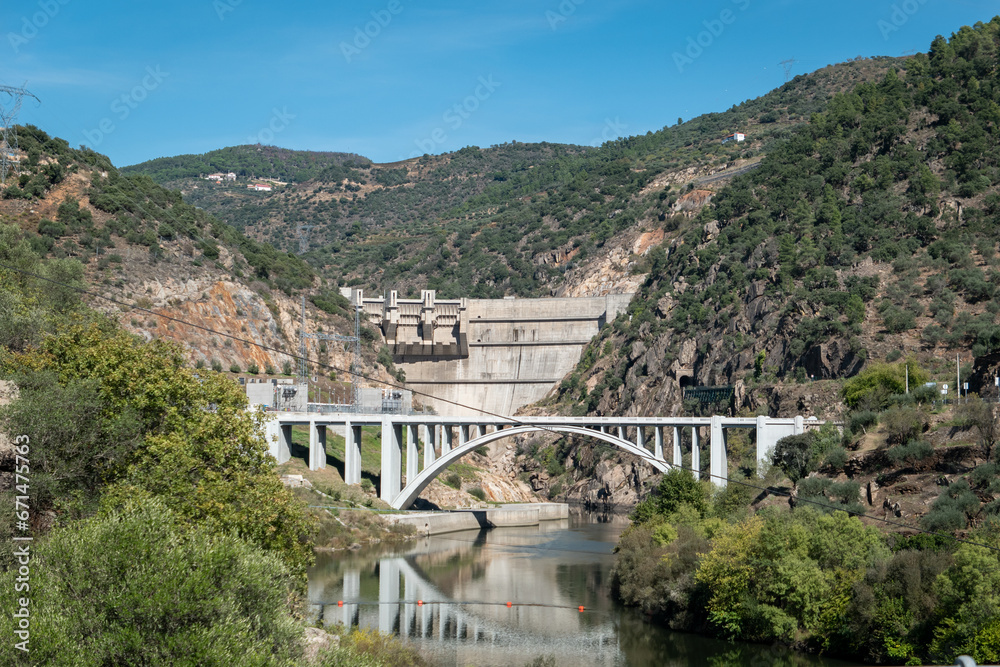 Entre montes e montanhas, a ponte sobre o rio Tua e mais atrás ao fundo uma barragem para a produção de eletricidade