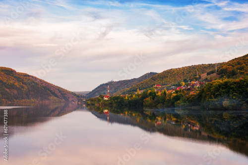 mountainous autumn landscape with lake in evening light. scenery in fall colors reflecting in the calm water. local tourism and relaxation concept