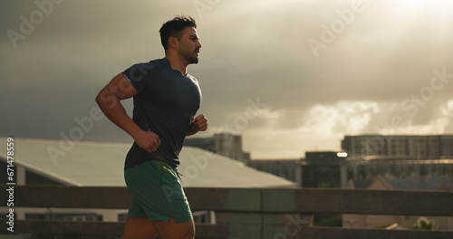 Running, city or man athlete in workout by training, cardio jog or fitness goals for marathon competition. Indian runner, wellness or progress in race, exercise or strong health body on urban road