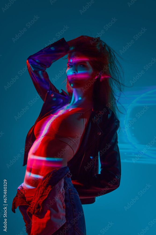 Beautiful, sensual young girl in underwear posing against blue background with neon lights reflection on body and face. Concept of modern art, beauty, style, futurism and cyberpunk, creativity