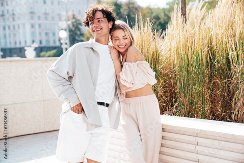 Portrait of young smiling beautiful woman and her handsome boyfriend in casual summer clothes. Happy cheerful family. Female having fun. Couple posing in the street background at sunny day