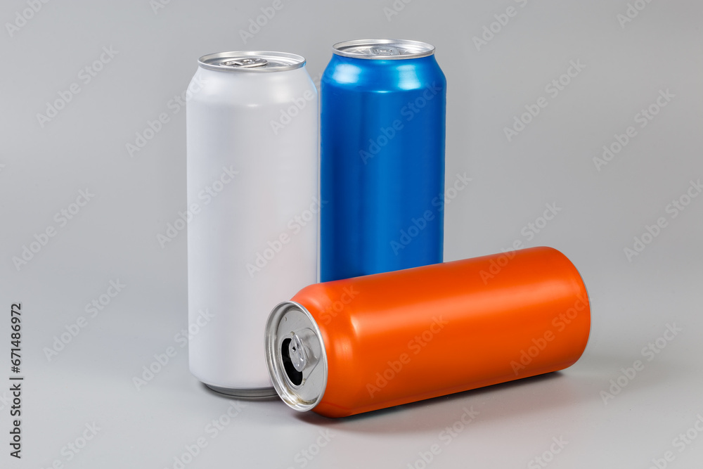 Sealed and open varicolored beverage cans on a gray background Sealed and open varicolored beverage cans on a gray background