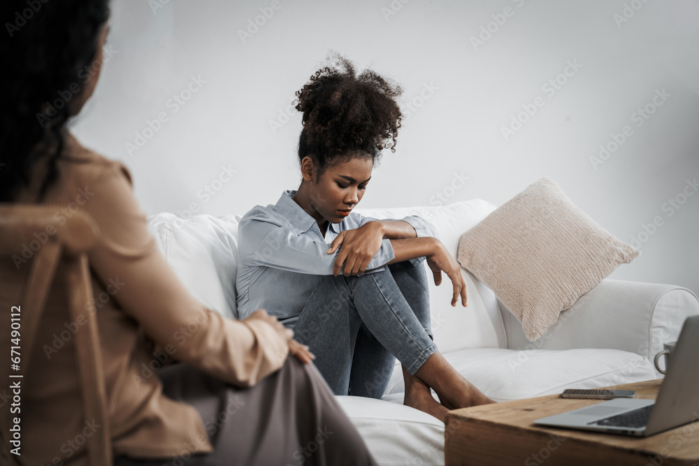 Sad PTSD woman patient in crucial therapy for mental health with psychologist, depression or grief after life failure. Frustrated trauma young woman talking to a psychologist about emotion in clinic - obrazy, fototapety, plakaty 
