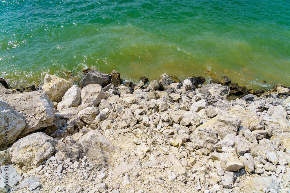 Obraz premium Rocky shore of a fresh reservoir. Background with selective focus and copy space