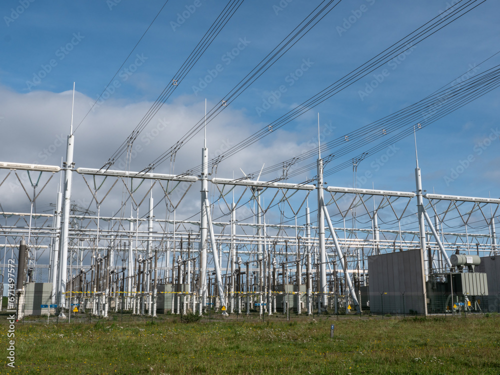 Electricity generator transformator at power plant and power lines pylons