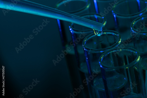 Close up of laboratory test tubes and pipette with copy space on blue background
