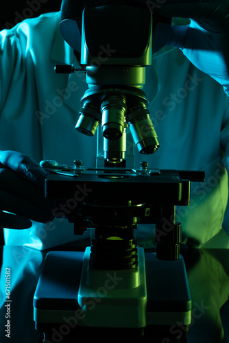 Vertical image scientist using microscope and copy space on black background