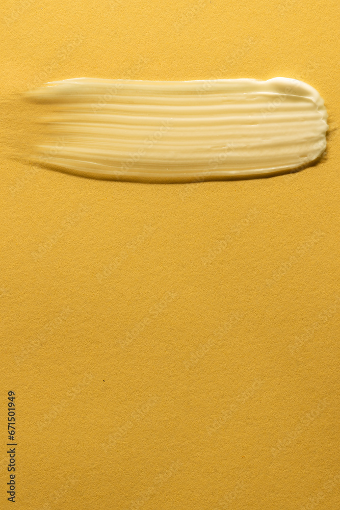 Vertical image of beauty product white cream smudge with copy space on yellow background Vertical image of beauty product white cream smudge with copy space on yellow background
