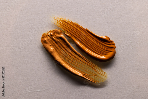 Close up of beauty product brown cream foundation smudges with copy space on white background